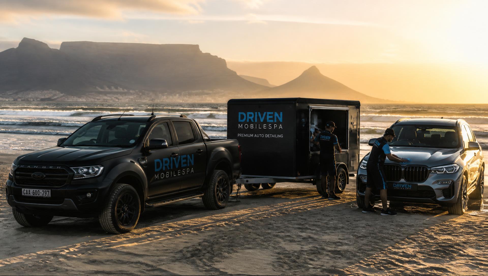 Driven Mobilespa branded trailer and pickup on Melkbosstrand beach with Table Mountain in the distance